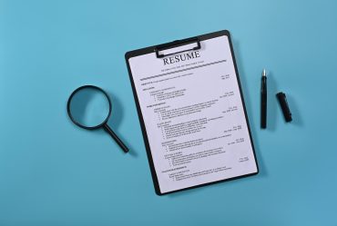 flat-lay-magnifying-glass-resumes-applicants-blue-background-job-search-concept